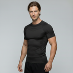 Man wearing a black BJJ rash guard on a gray background