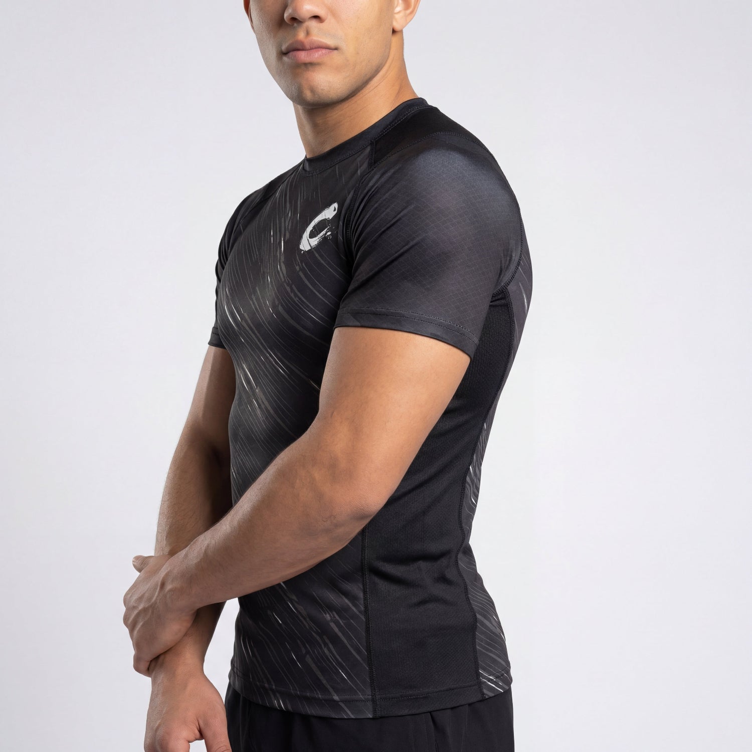 Person wearing a black athletic shirt with a logo on a light gray background
