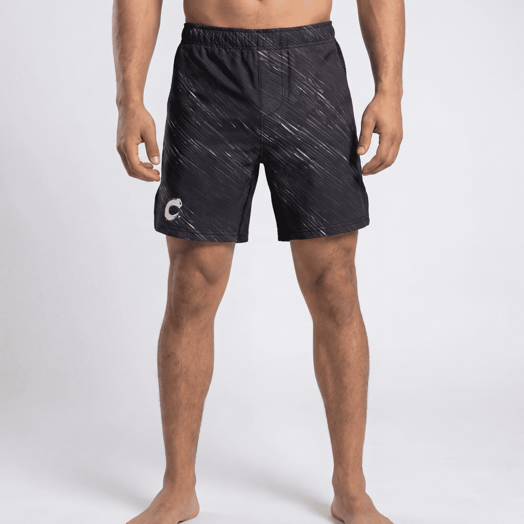 Person wearing black patterned shorts on a white background